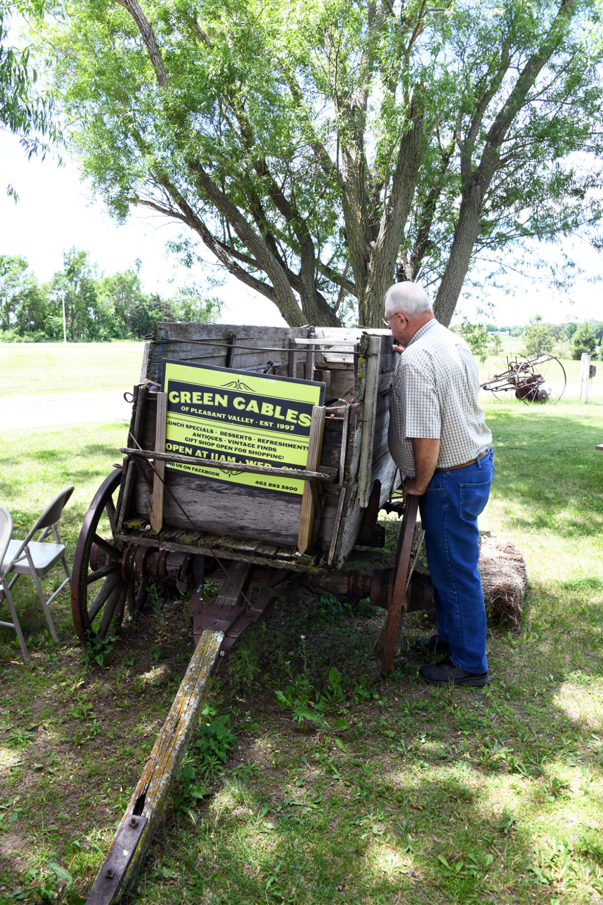 178 Jim Bulgrin examines the old farm equipment at the Green Gables between Royal and Orchard, NE.JPG